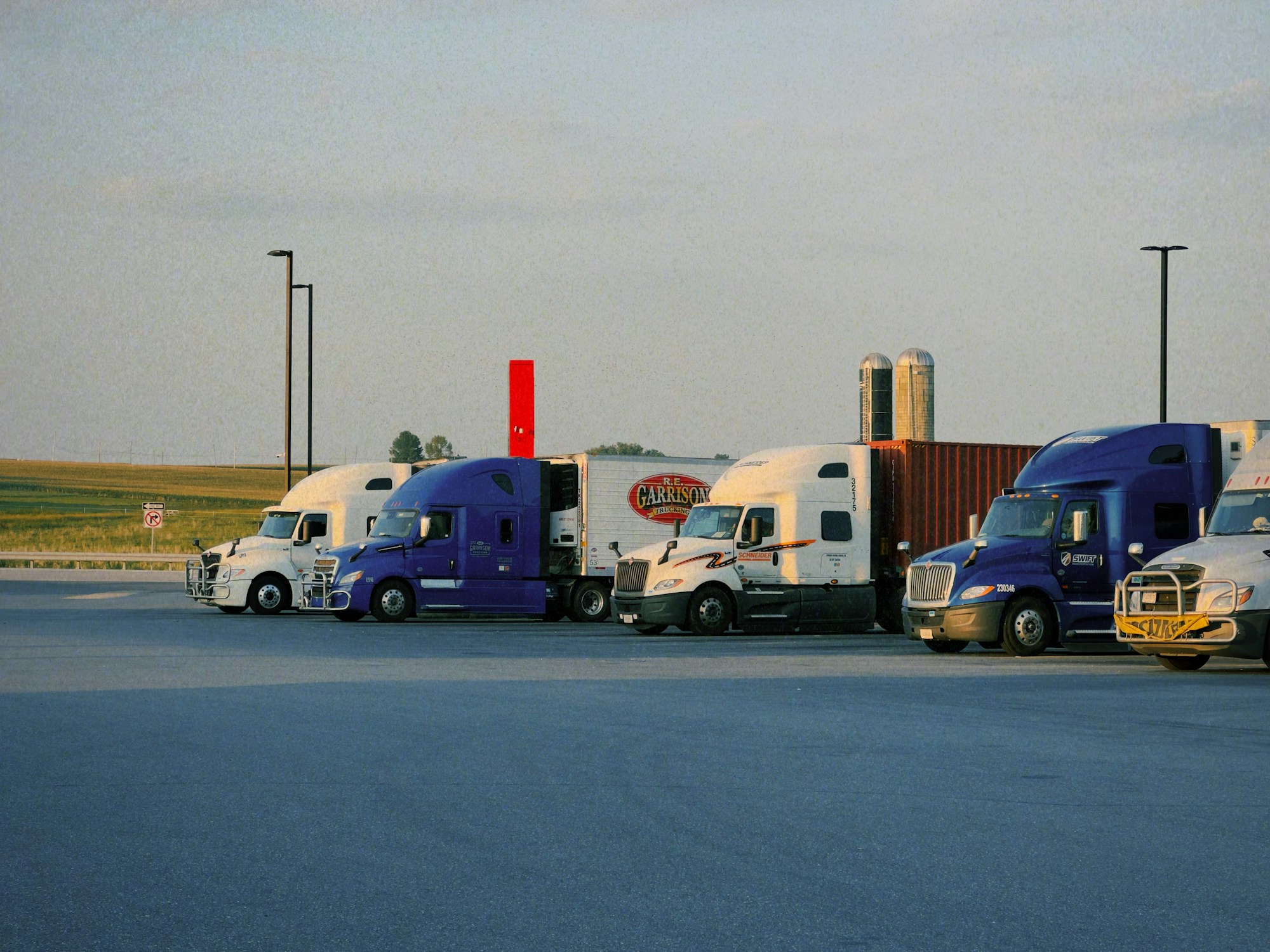 Semi-trucks lined up in a fleet parking yard